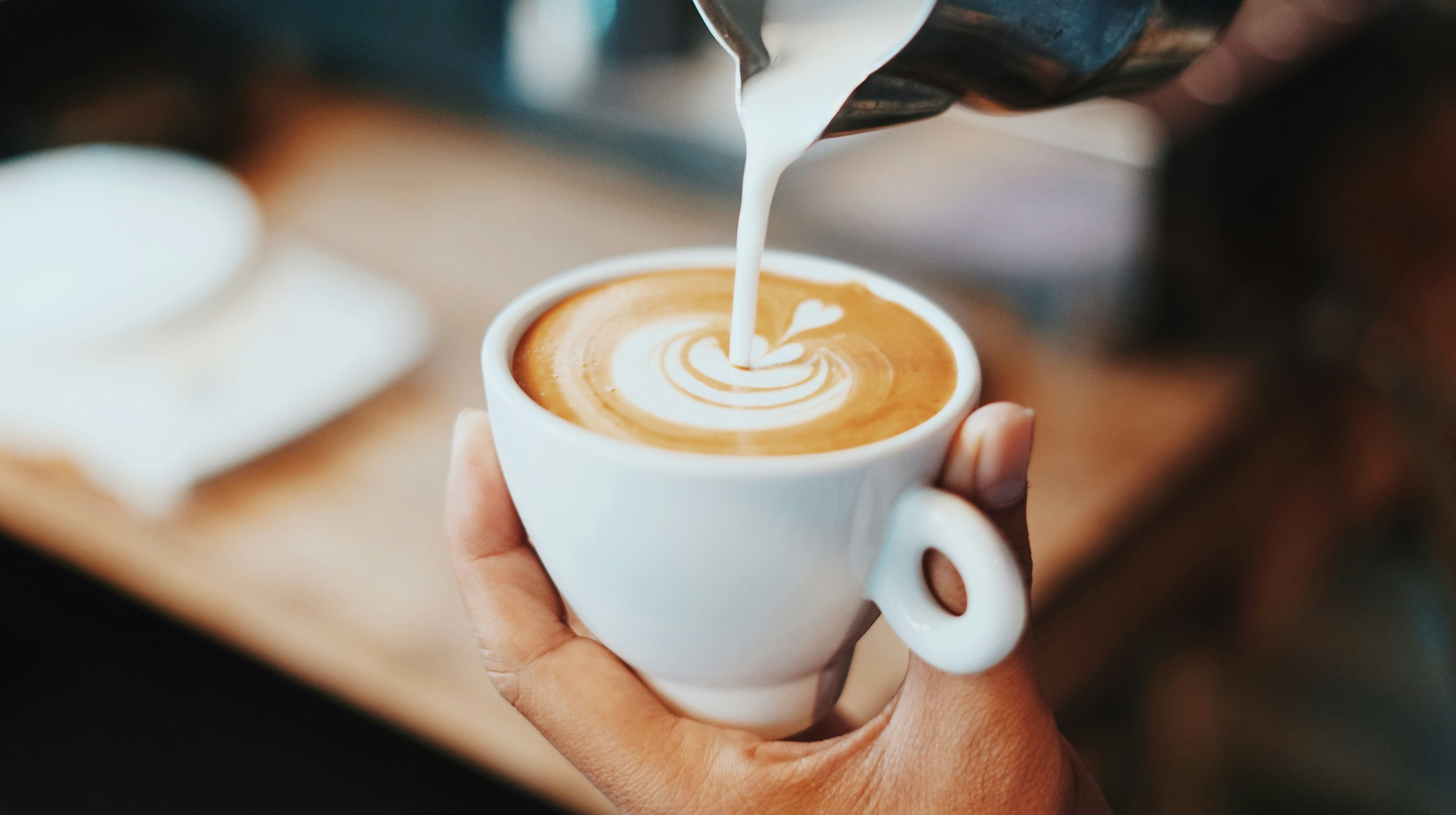 Persona dibujando arte en un latte